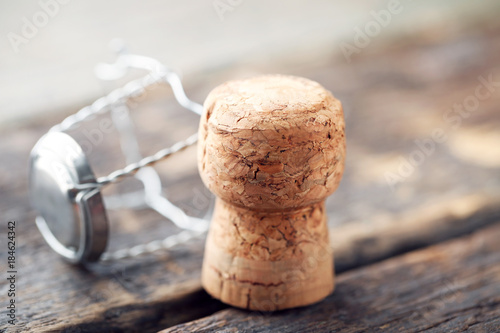 Champagne cork with cap on grey wooden table