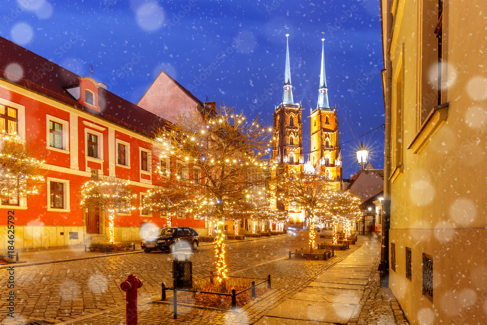 Fototapeta premium Cathedral of St. John at Cathedral Island or Ostrow Tumski at snowy christmas night in Wroclaw, Poland