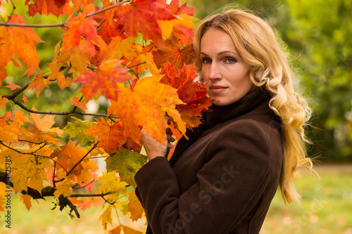 Beautiful woman dreams under an autumn tree