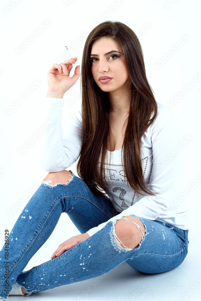 Beautiful young girl wearing a jeans and white t-shirt and smoking cigaret  Stock Photo | Adobe Stock