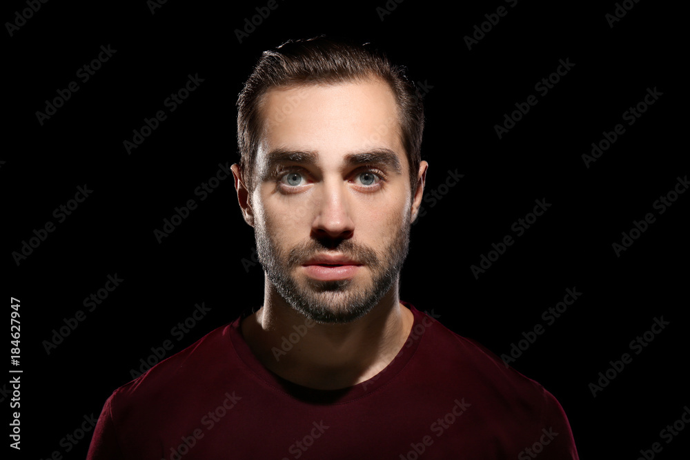 Young handsome man on black background