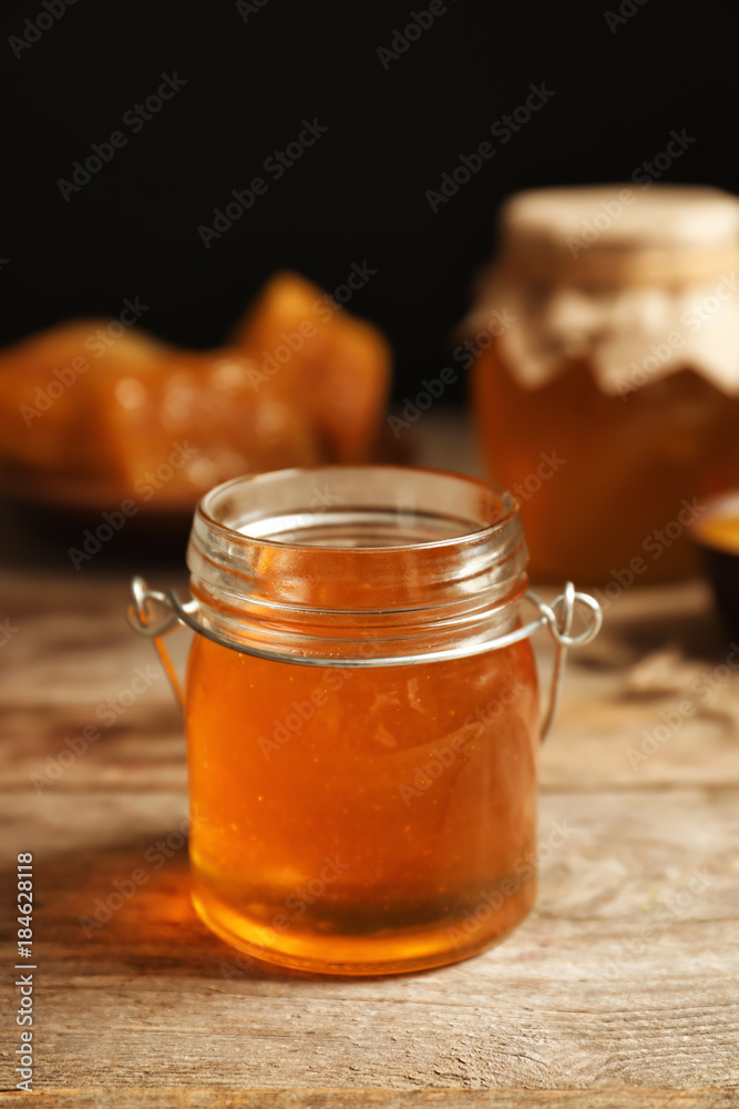 Glass jar with honey on wooden table Glass jar with honey on wooden table