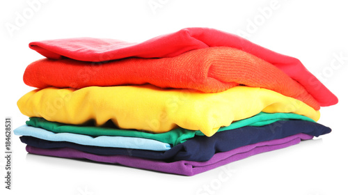 Folded rainbow clothes on white background
