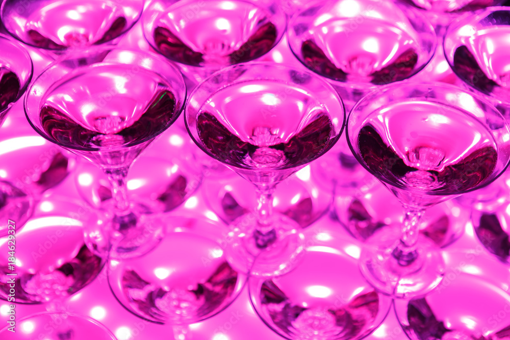 Glasses with sparkling wine lit from below crimson light Glasses with sparkling wine lit from below crimson light