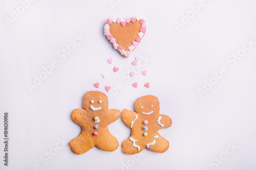 Gingerbread cookies couple for Valentines Day. Man and woman with emotions in the shape of hearts on the white background. Love and happy family concept. Selective focus. Space for text © okrasiuk