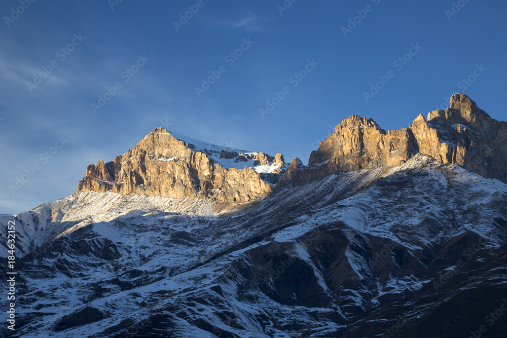 Горный пейзаж. Высокие скалы в живописном ущелье, зима, белые облака на синем небе. Дикая природа Северного Кавказа