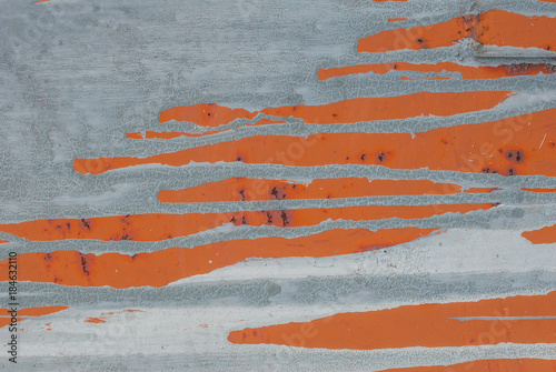 iron surface is covered with remnants of old paint, grey and orange color texture, background