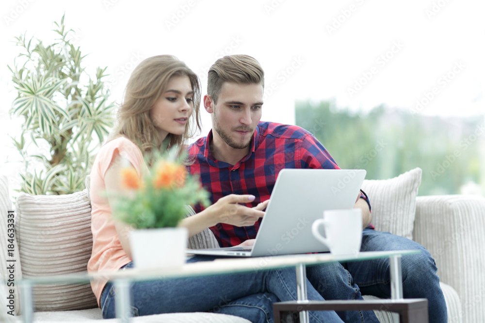 young woman showing important information to her boyfriend on the laptop screen