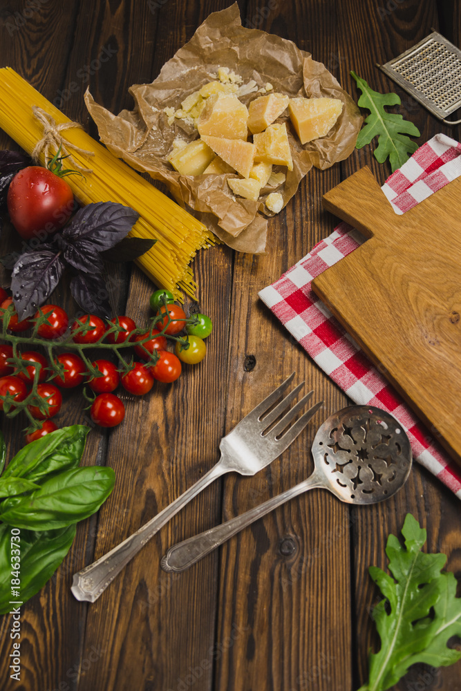 Pasta background. Dry spaghetti with vegetables and herbs on a wooden table. Pasta background. Dry spaghetti with vegetables and herbs on a wooden table.