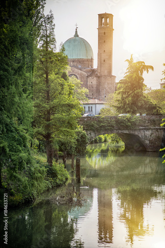 View to park and bridge over river on background of historic building in Treviso, Italy. 