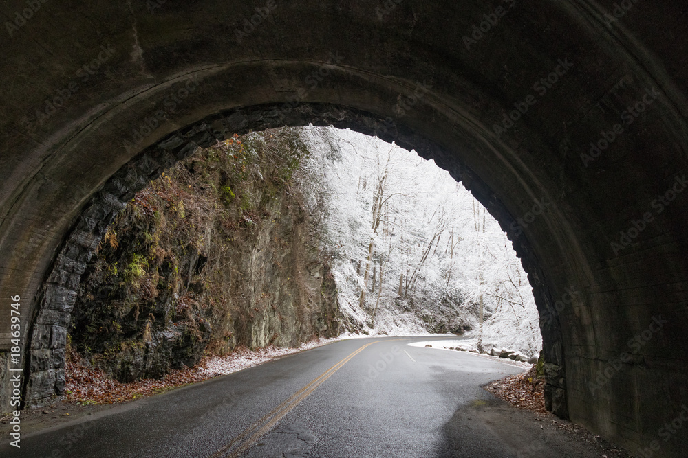 Tunnel and curvy windy road through snow covered woods in Great Smoky Mountains National Park