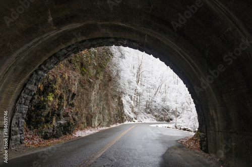 Tunnel and curvy windy road through snow covered woods in Great Smoky Mountains National Park