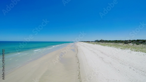 Fototapeta Naklejka Na Ścianę i Meble -  Drone aerial view of wide open white sandy beach, taken at Tennyson, South Australia with nearby luxury two story homes overlooking the coast.
