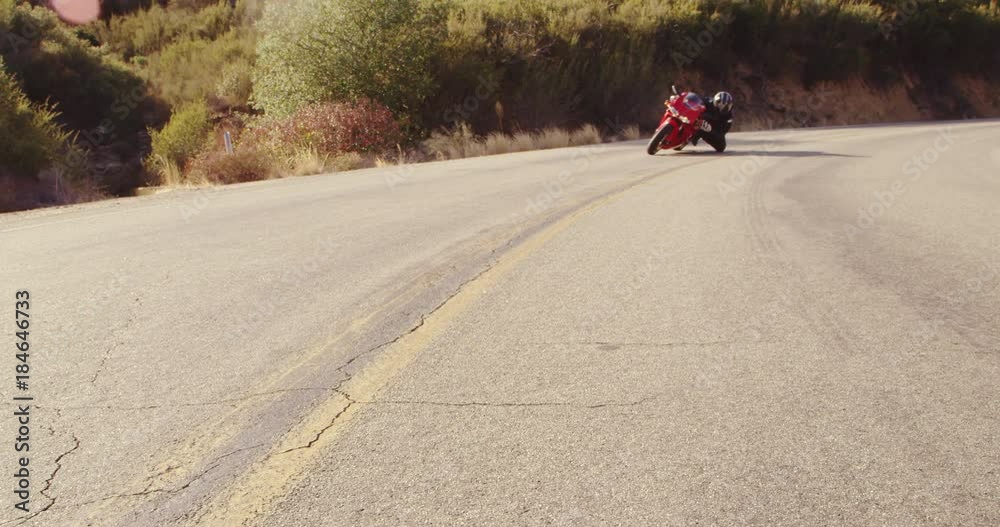 Extreme Motorcyclist Riding Sport Bike on Turn on a Curvy Road With Lens Flare Filmed In Slow Motion Extreme Motorcyclist Riding Sport Bike on Turn on a Curvy Road With Lens Flare Filmed In Slow Motion