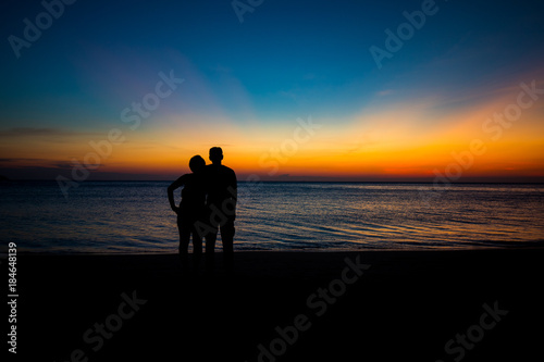 Male silhouette woman standing hugging at the seaside with twilight © Suwun