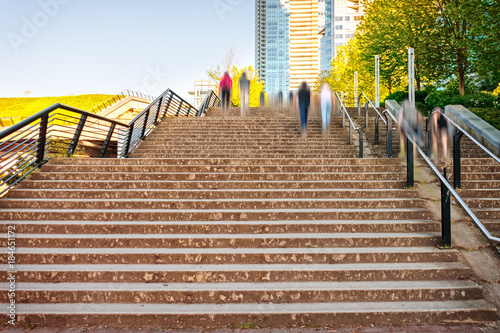 in the city people climb up the wide modern staircase