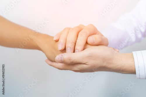Two people holding hands for comfort. Doctor consoling relatives of patients in hospital concept photo