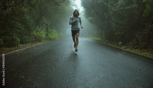 Fotografie, Obraz Handsome jogger running in the exotic area