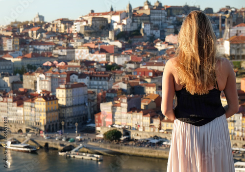 Undefined young woman watching sunset on old town Porto city, Portugal
