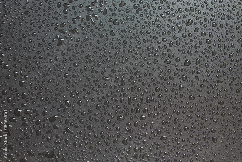 Small liquid drops on a black background.