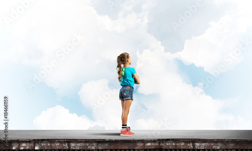 Concept of careless happy childhood with girl looking far away