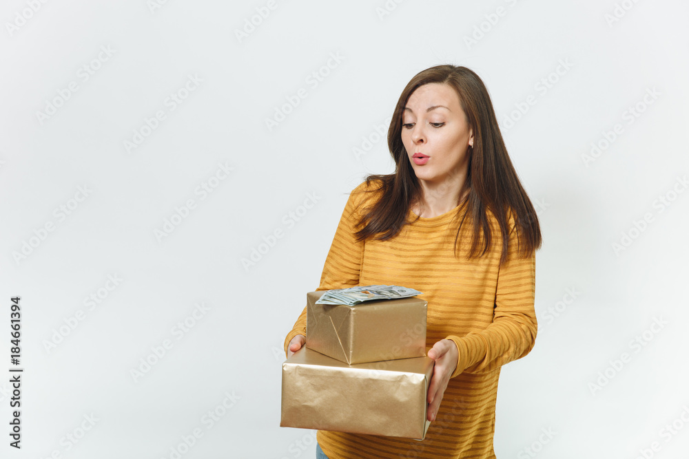 Beautiful caucasian fun young happy birthday woman in yellow clothes holding wad of cash money, golden gift boxes with present, celebrating holiday party on white background isolated for advertisement Beautiful caucasian fun young happy birthday woman in yellow clothes holding wad of cash money, golden gift boxes with present, celebrating holiday party on white background isolated for advertisement