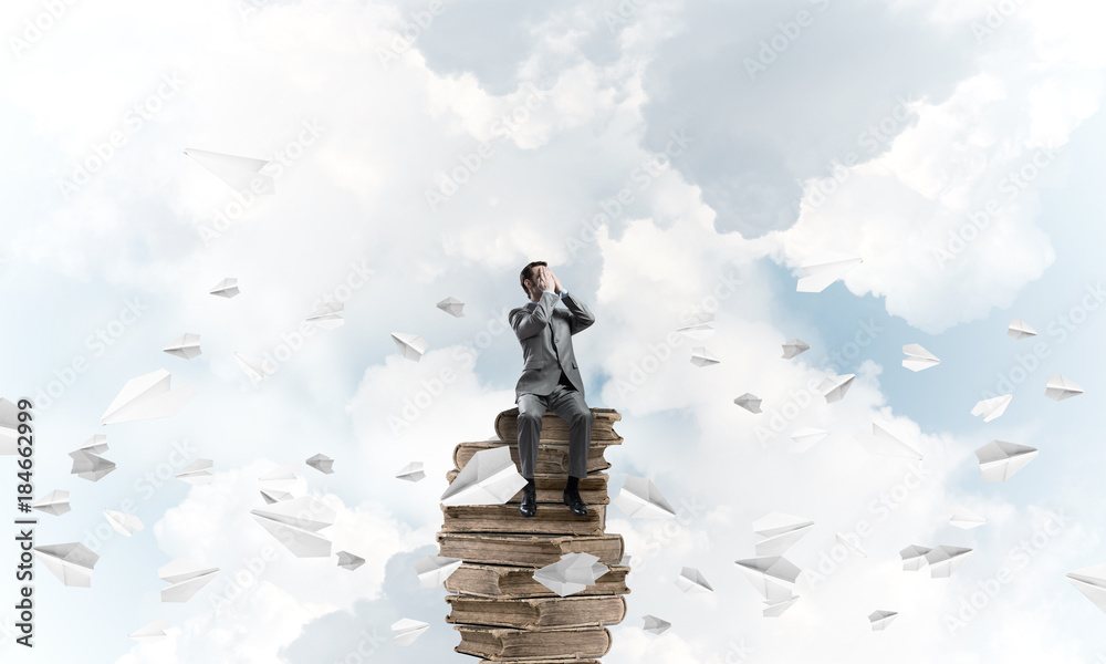 Young man do not want to see anything and paper planes fly around Young man do not want to see anything and paper planes fly around