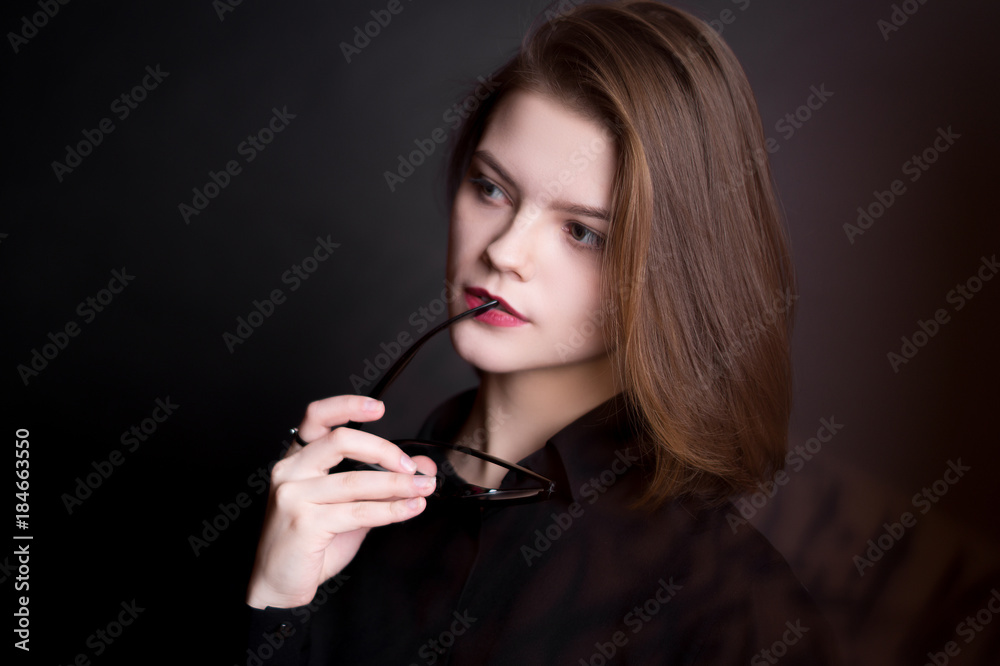 Beautiful model in glasses on a black background in studio Beautiful model in glasses on a black background in studio