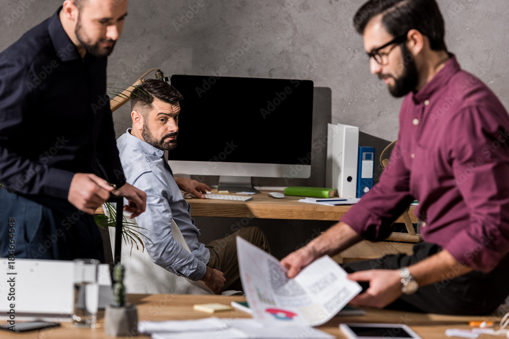Fototapeta premium handsome businessman taking documents from working table
