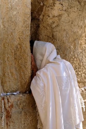 Unrecognized praying man in white tallit at the Wailing Wall in Jerusalem.