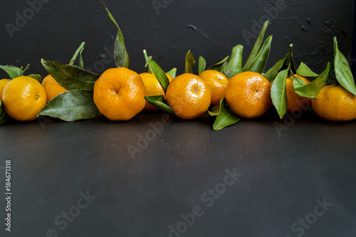 Ripe tangerines on a black background.