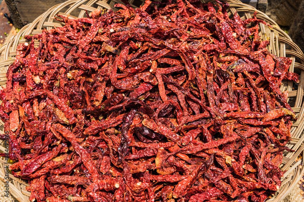 Fototapeta premium Dried Chili Peppers in basket on the wooden table background