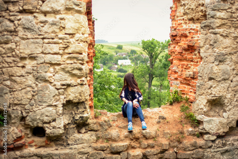 ..The girl is sitting on a high wall