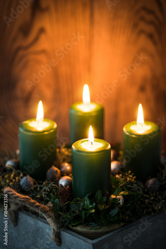 Adventsgesteck mit vier brennenden Kerzen