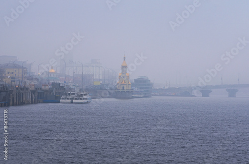 Misty winter morning. View to the embankment near the river port. City landscape. Kyiv, Ukraine