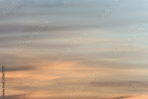 Sunset sky background with a golden orange glow on a hazy clouds