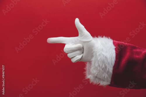 Santa Claus hand pointing finger against a red background