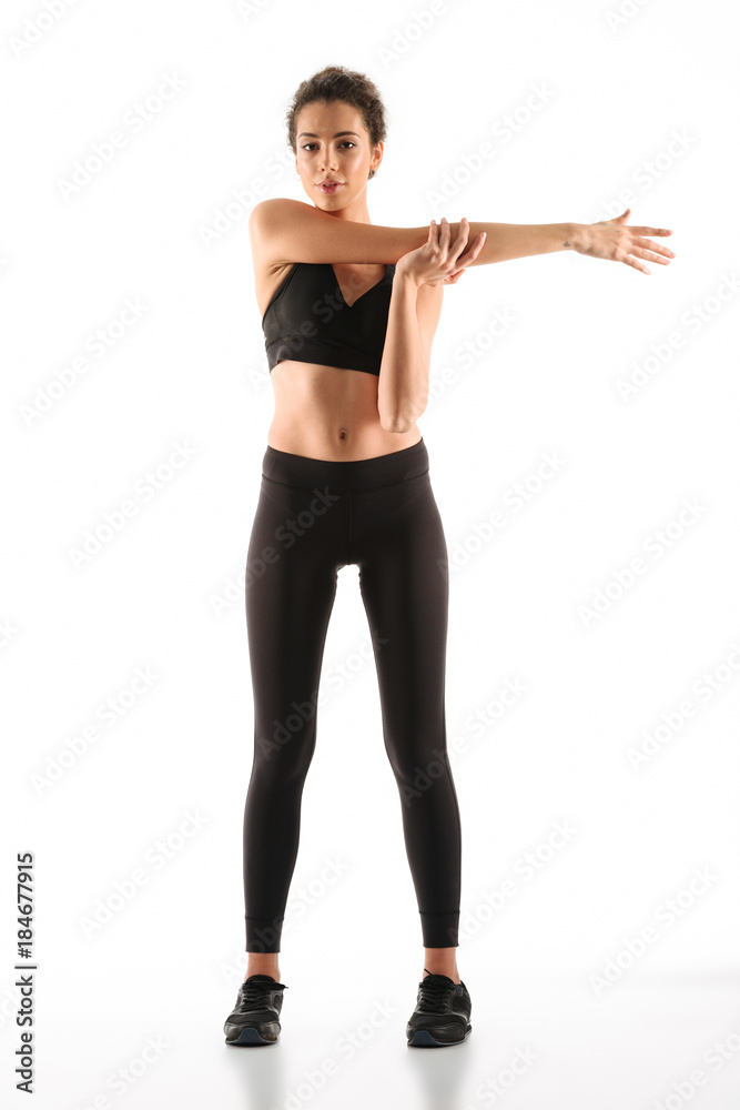 Full length image of Pleased fitness woman warming up