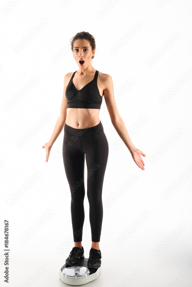 Full length image of Shocked curly brunette fitness woman Full length image of Shocked curly brunette fitness woman