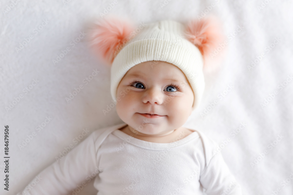 Cute adorable baby child with warm white and pink hat with cute bobbles Cute adorable baby child with warm white and pink hat with cute bobbles