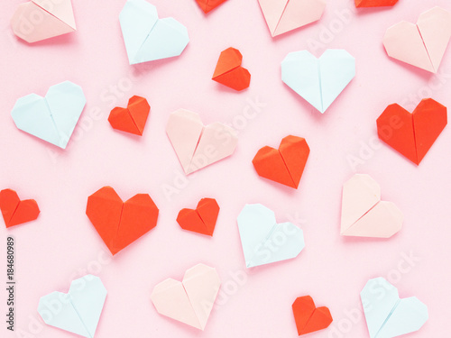 Pattern of paper origami hearts on a pink background. Valentine's day background. 