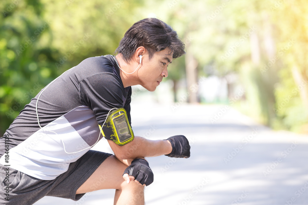 Fototapeta premium Fitness sport young man runner doing stretching exercise in the park.Healthy concept