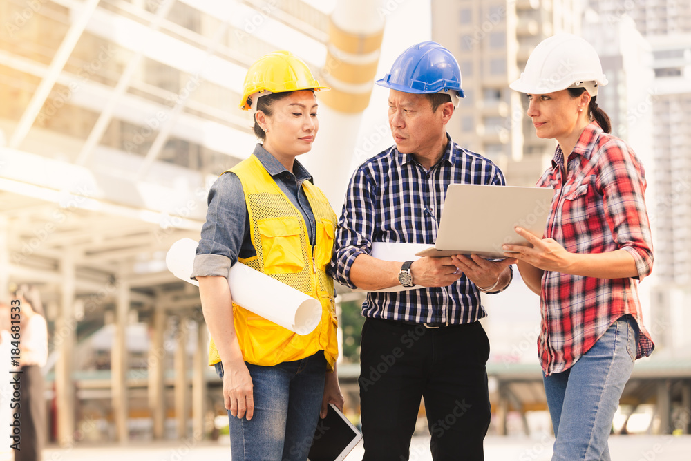 Engineers man and woman working on plan building construction in city Engineers man and woman working on plan building construction in city