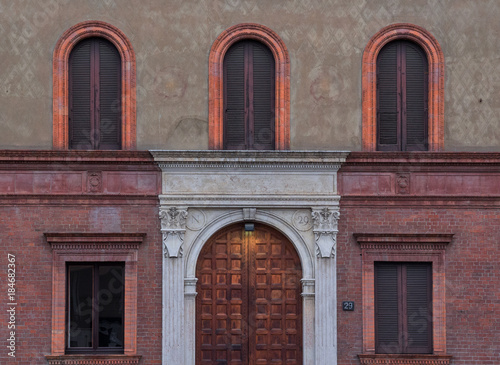 ancient entrance of a building in Milan, Italy, engraved with the Napoleonic symbol