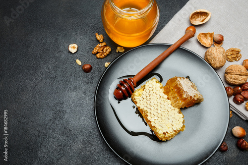 Honeycomb with honey on plate. dark concrete background