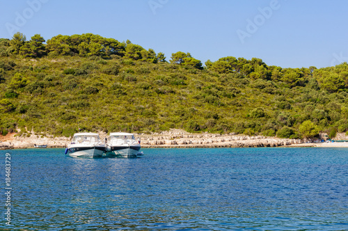 Two yachts anchored side by side in the beautiful  Milne Bay - Hvar, Croatia photo