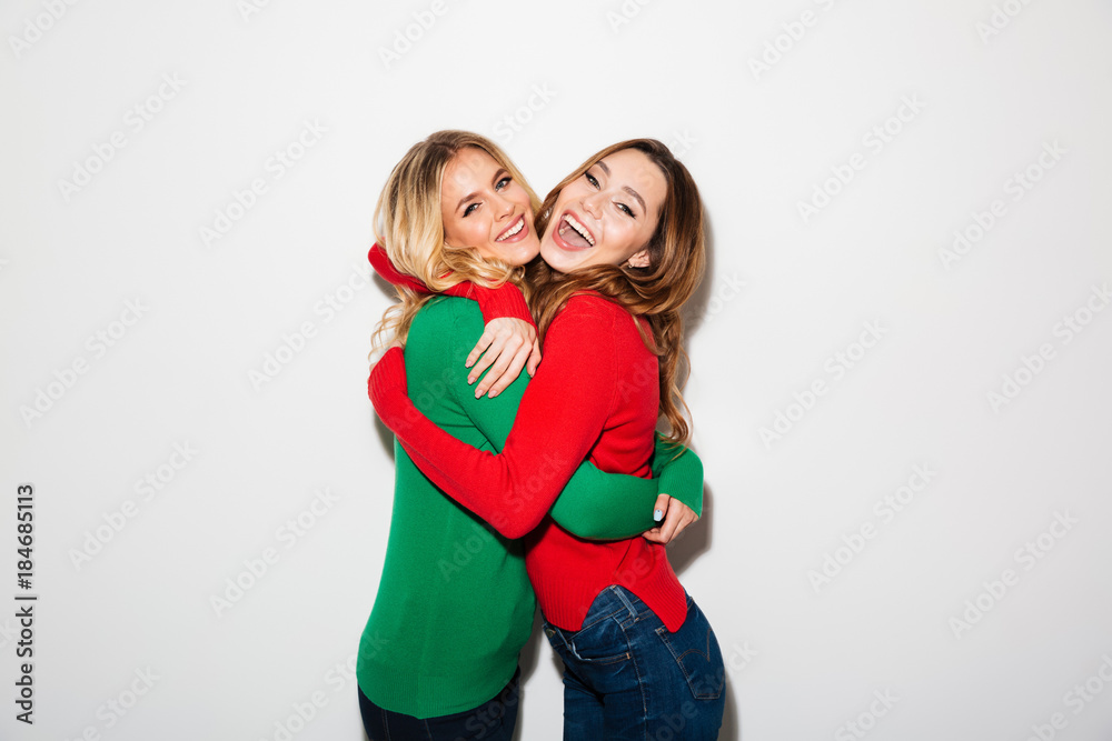 Portrait of two cheery girls dressed in sweaters Portrait of two cheery girls dressed in sweaters