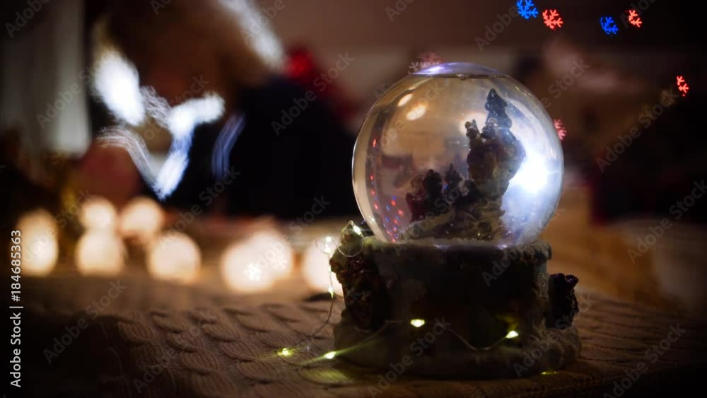 snow globe and women on blurred background in backlight with figure bokeh
