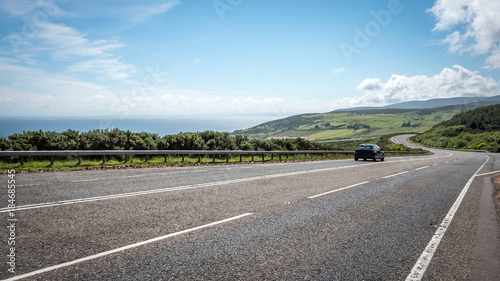Scottish Highland road trip. A quiet coastal road running through the Highlands of Scotland on a bright summers day.