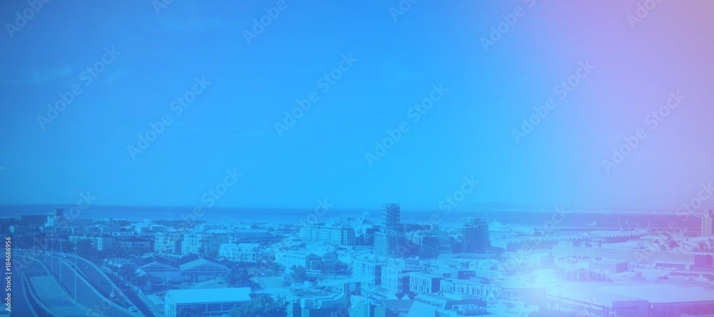 Obraz premium Cityscape by sea against blue sky
